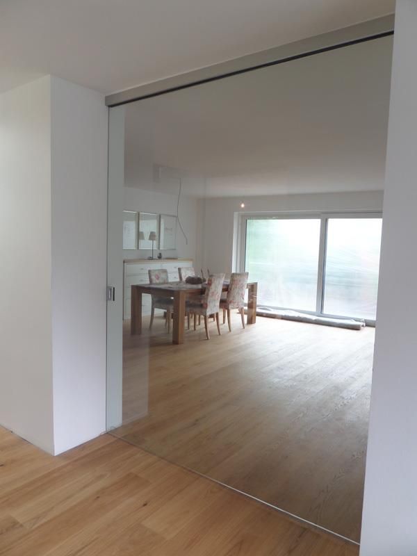 Ein Esszimmer mit Tisch und Stühlen und einer Glasschiebetür