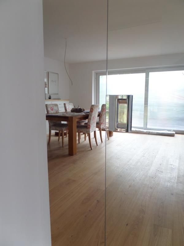 Ein Wohnzimmer mit einem Tisch und Stühlen und einem Spiegel an der Wand.