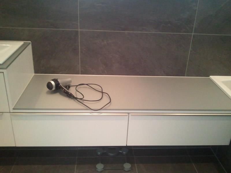 Ein Haartrockner steht auf einer Ablage in einem Badezimmer