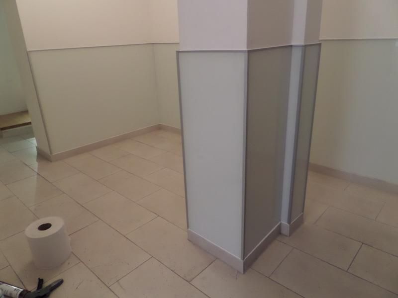 Ein Raum mit einer Säule und einer Rolle Toilettenpapier auf dem Boden.