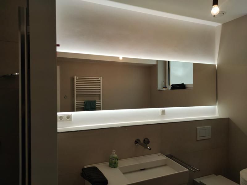 Ein Badezimmer mit Waschbecken und großem Spiegel