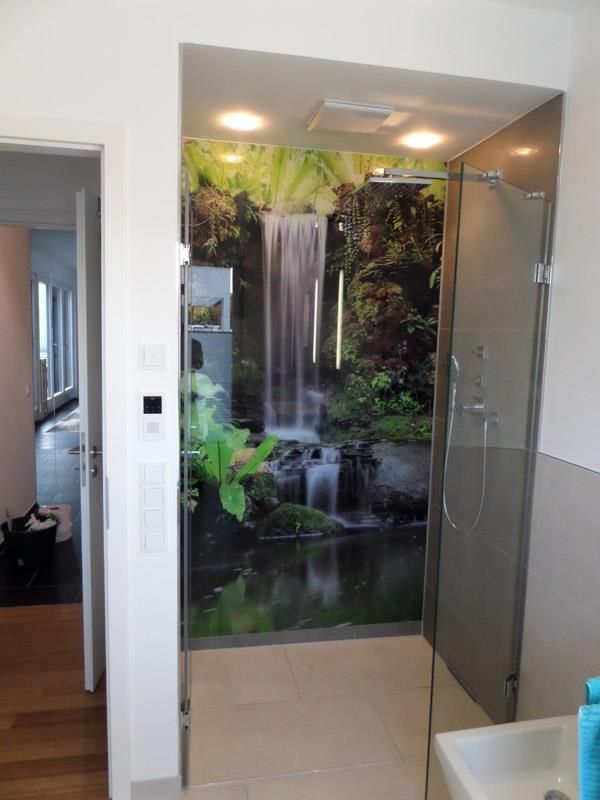 Ein Badezimmer mit einem Bild eines Wasserfalls an der Wand