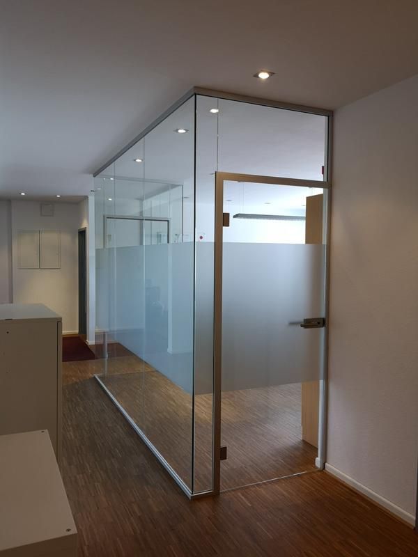 Ein Flur mit einer Glaswand und einer Tür