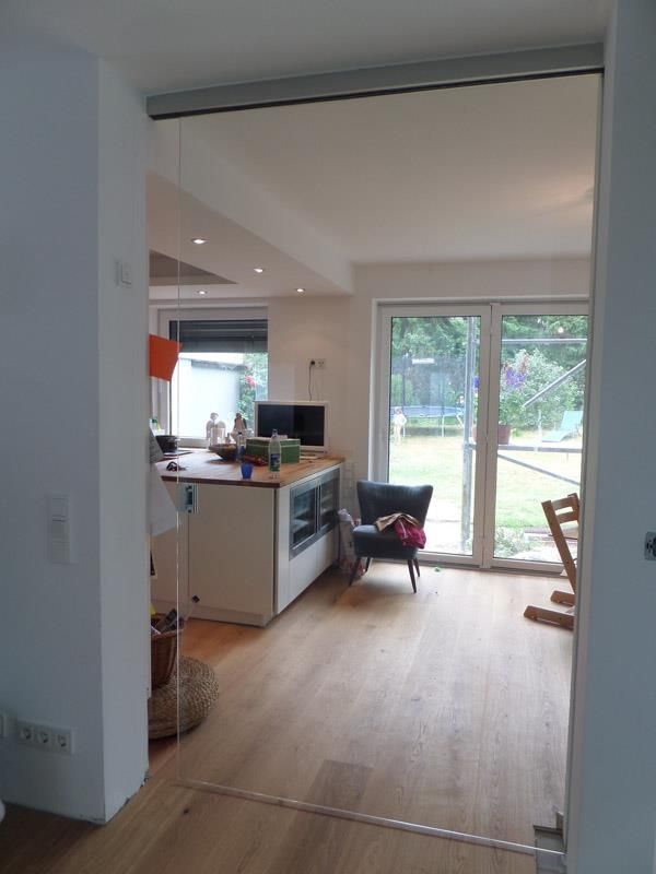 Ein Wohnzimmer mit Hartholzböden und einer Glasschiebetür