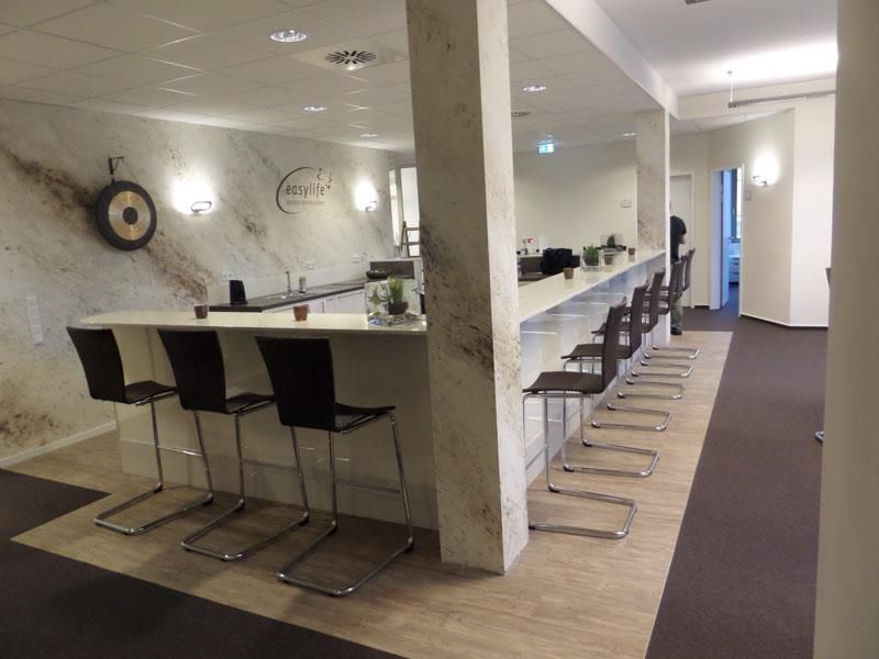 Ein Raum mit einer Bar und Stühlen und einer Uhr an der Wand