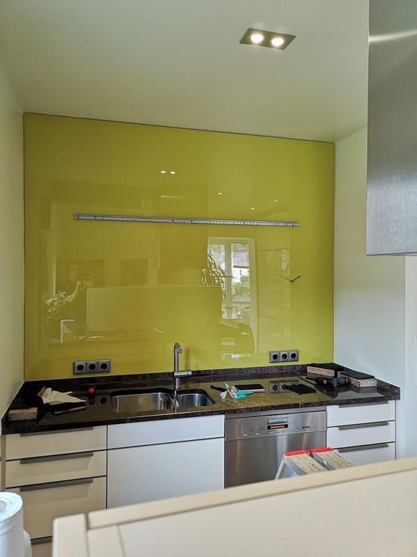 Eine Küche mit gelber Wand und Geräten aus Edelstahl