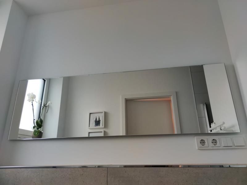 Ein großer Spiegel hängt an einer Wand in einem Badezimmer