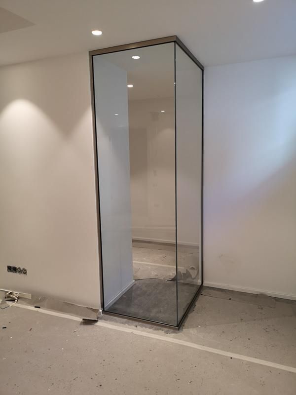 Ein Raum mit einer Glastür und einer weißen Wand.