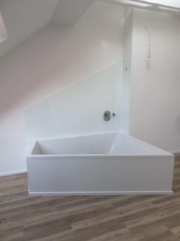 In der Ecke eines Badezimmers steht eine Badewanne.