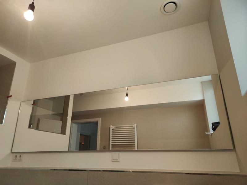 Ein Badezimmer mit großem Spiegel und Handtuchhalter