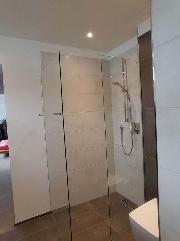 Ein Badezimmer mit ebenerdiger Dusche und Toilette