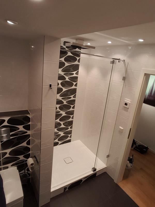 Ein Badezimmer mit ebenerdiger Dusche und Toilette.