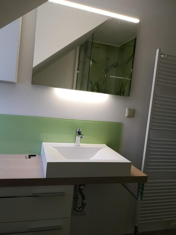 Ein Badezimmer mit einem Waschbecken und einem Spiegel darüber