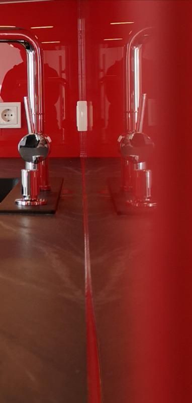 Eine rote Küche mit Spüle und Wasserhahn