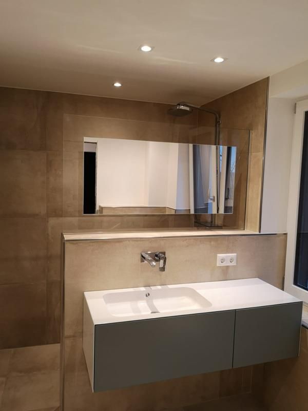 Ein Badezimmer mit Waschbecken, Spiegel und Dusche.