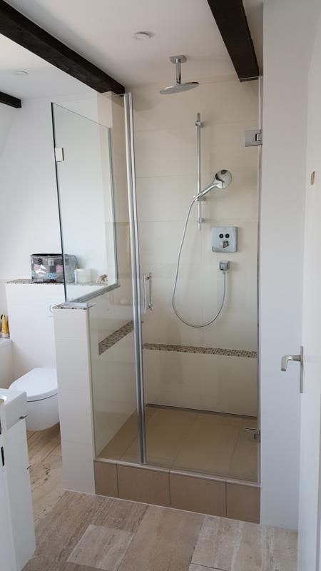 Ein Badezimmer mit ebenerdiger Dusche und Toilette.