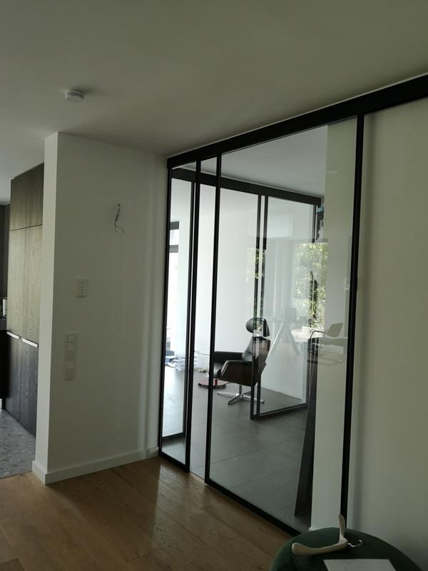 Ein Wohnzimmer mit Glasschiebetüren und einem Stuhl.