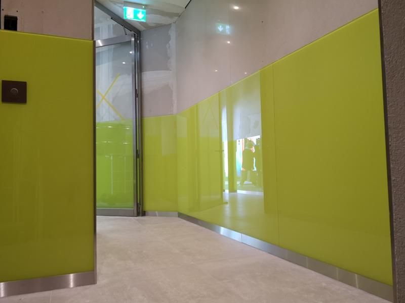 Ein Flur mit grünen Wänden und einer Glastür.