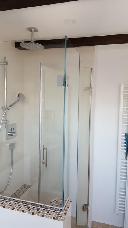 Ein Badezimmer mit Glasduschtür und Handtuchhalter.