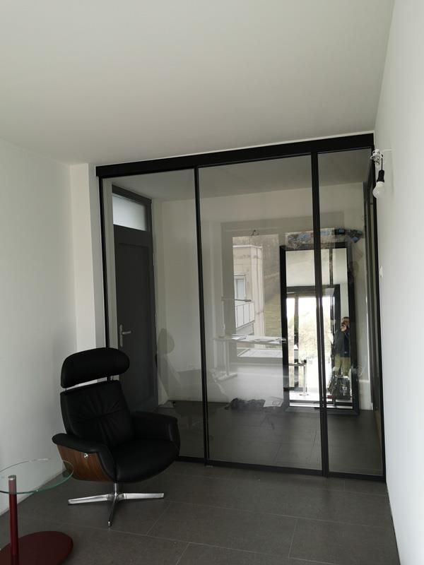 Ein Raum mit einem Stuhl und Glasschiebetüren