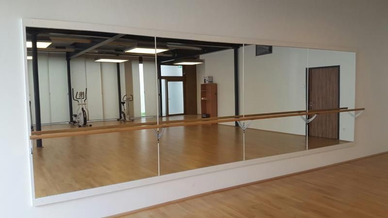 In einem Tanzstudio hängt ein großer Spiegel an der Wand.