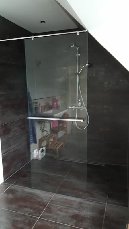 Ein Badezimmer mit ebenerdiger Dusche und Waschbecken.