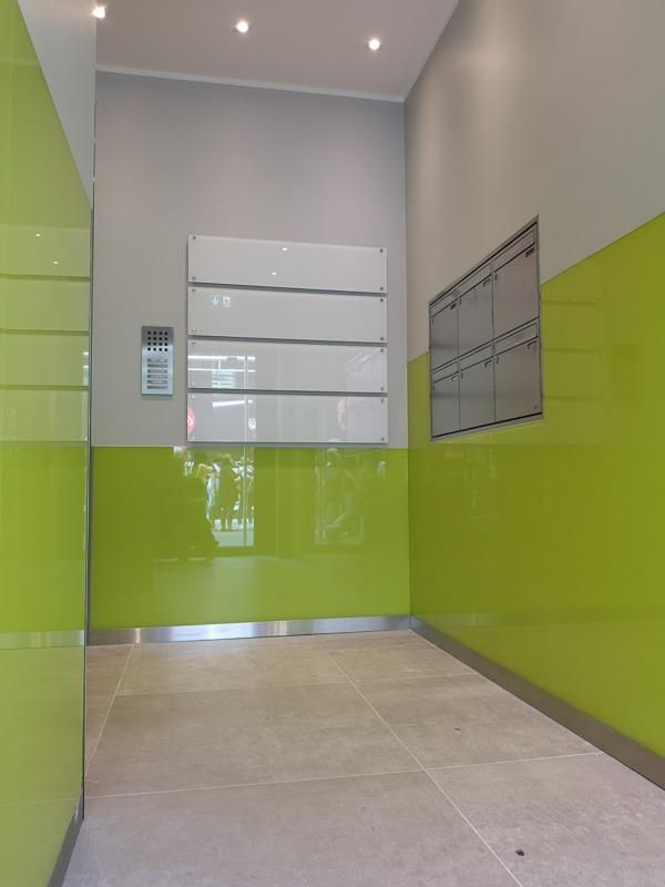 Ein Flur mit grünen Wänden und einer weißen Tafel an der Wand.