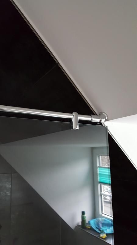 In einem Badezimmer hängt ein Spiegel von der Decke.