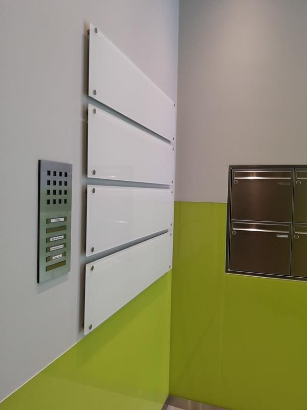 Ein Raum mit grünen Wänden und weißen Tafeln an der Wand