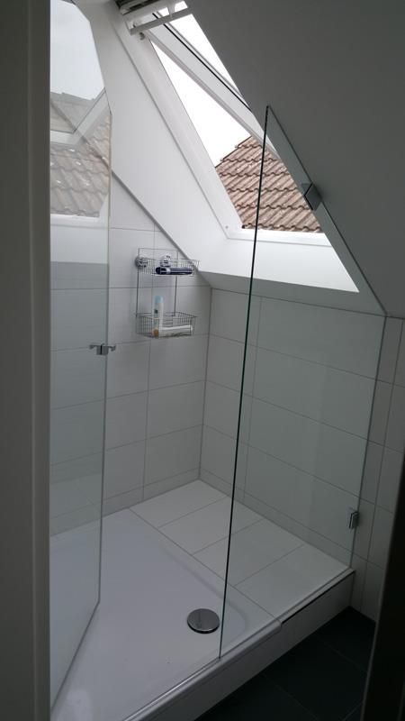 Ein Badezimmer mit ebenerdiger Dusche und Oberlicht.
