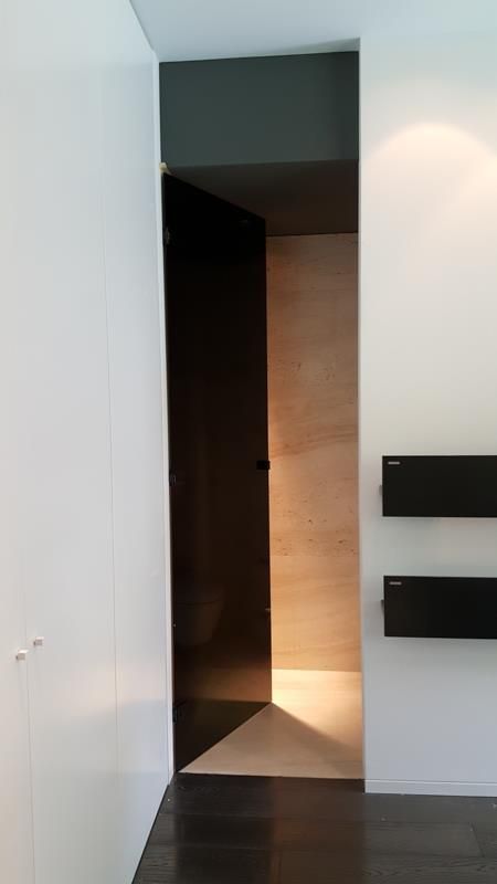 Ein Flur mit einer schwarzen Tür und einer weißen Wand.