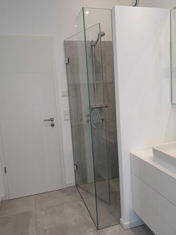 Ein Badezimmer mit ebenerdiger Dusche und Waschbecken.