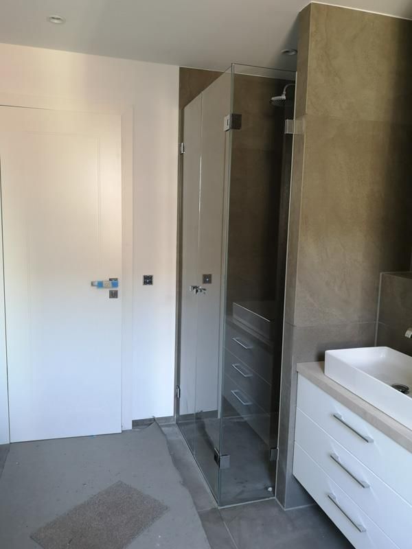 Ein Badezimmer mit Waschbecken und ebenerdiger Dusche