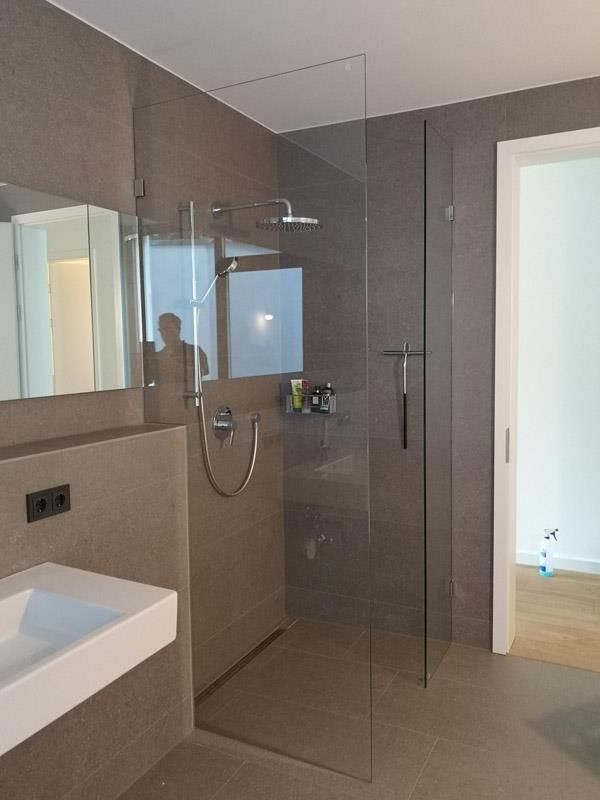 Ein Badezimmer mit ebenerdiger Dusche und Waschbecken