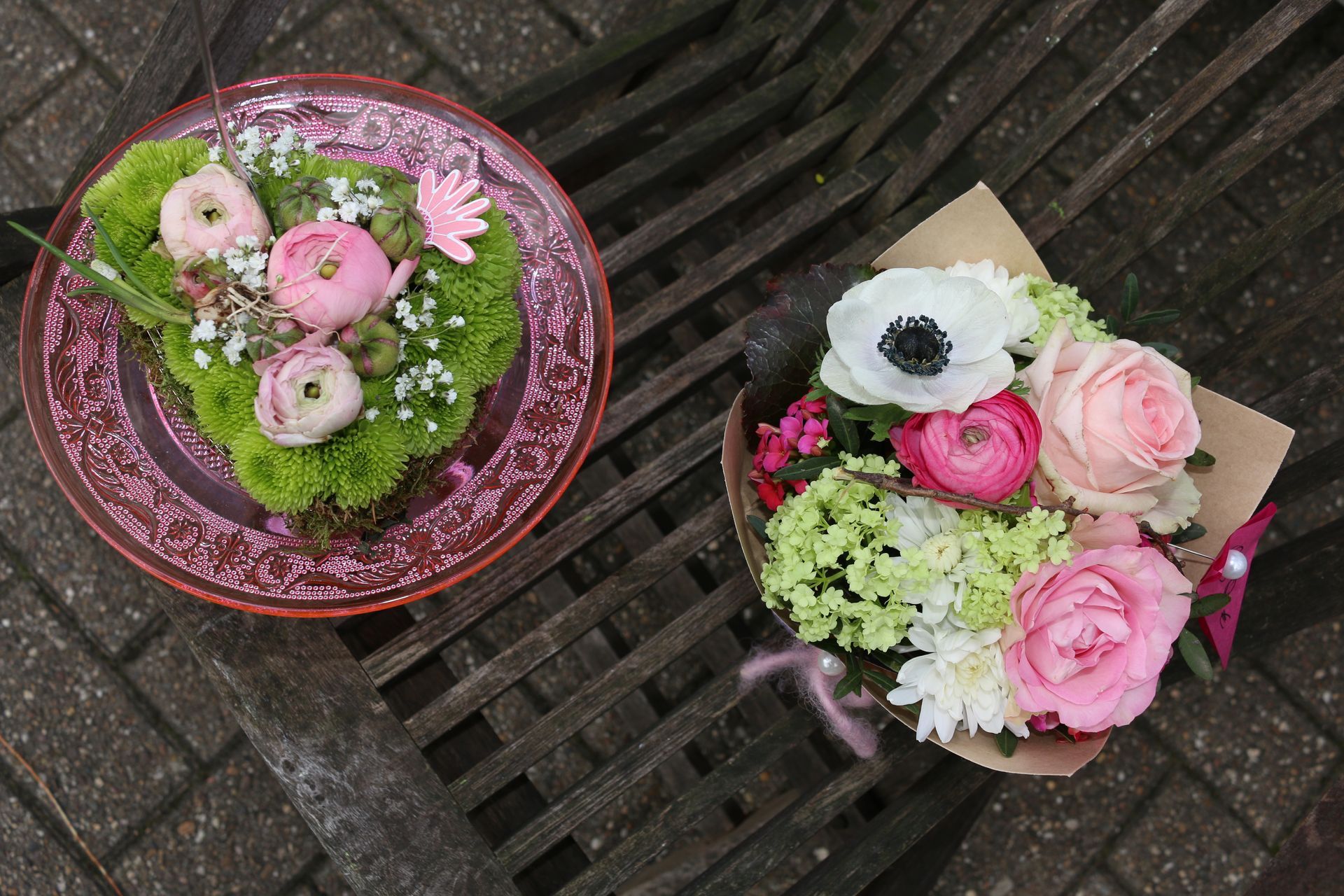 Zwei bunte Blumensträuße auf einem Gartenstuhl