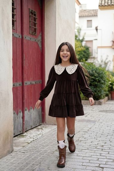 Una niña con un traje blanco sostiene un paraguas.