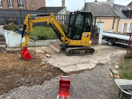 Une mini-pelle jaune en action