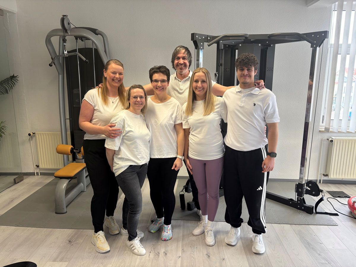 Eine Gruppe von Menschen posiert in einem Fitnessstudio für ein Foto.