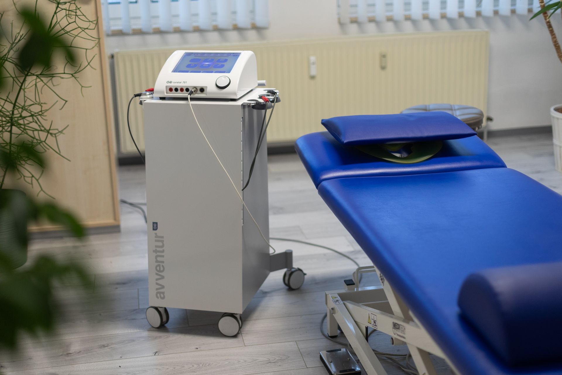 Ein blaues Bett mit einer Maschine darauf in einem Zimmer.