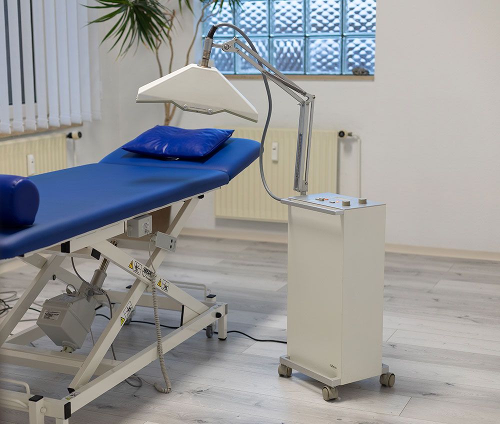 Ein blaues Krankenbett mit einer Lampe darauf