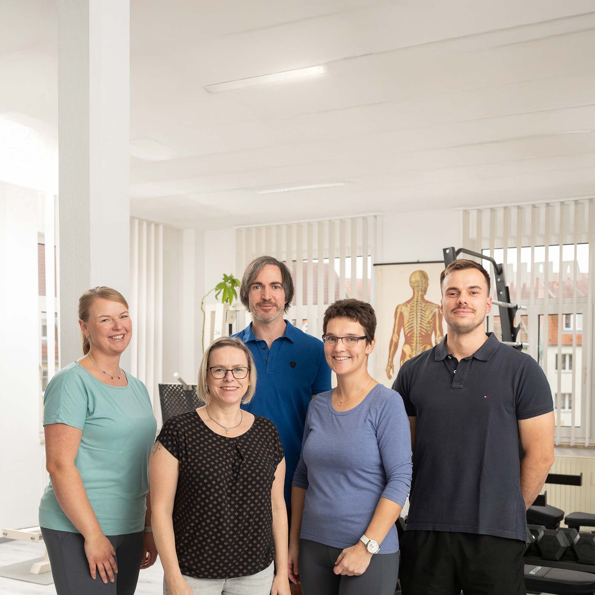 Eine Gruppe von Menschen posiert in einem Fitnessstudio für ein Foto.