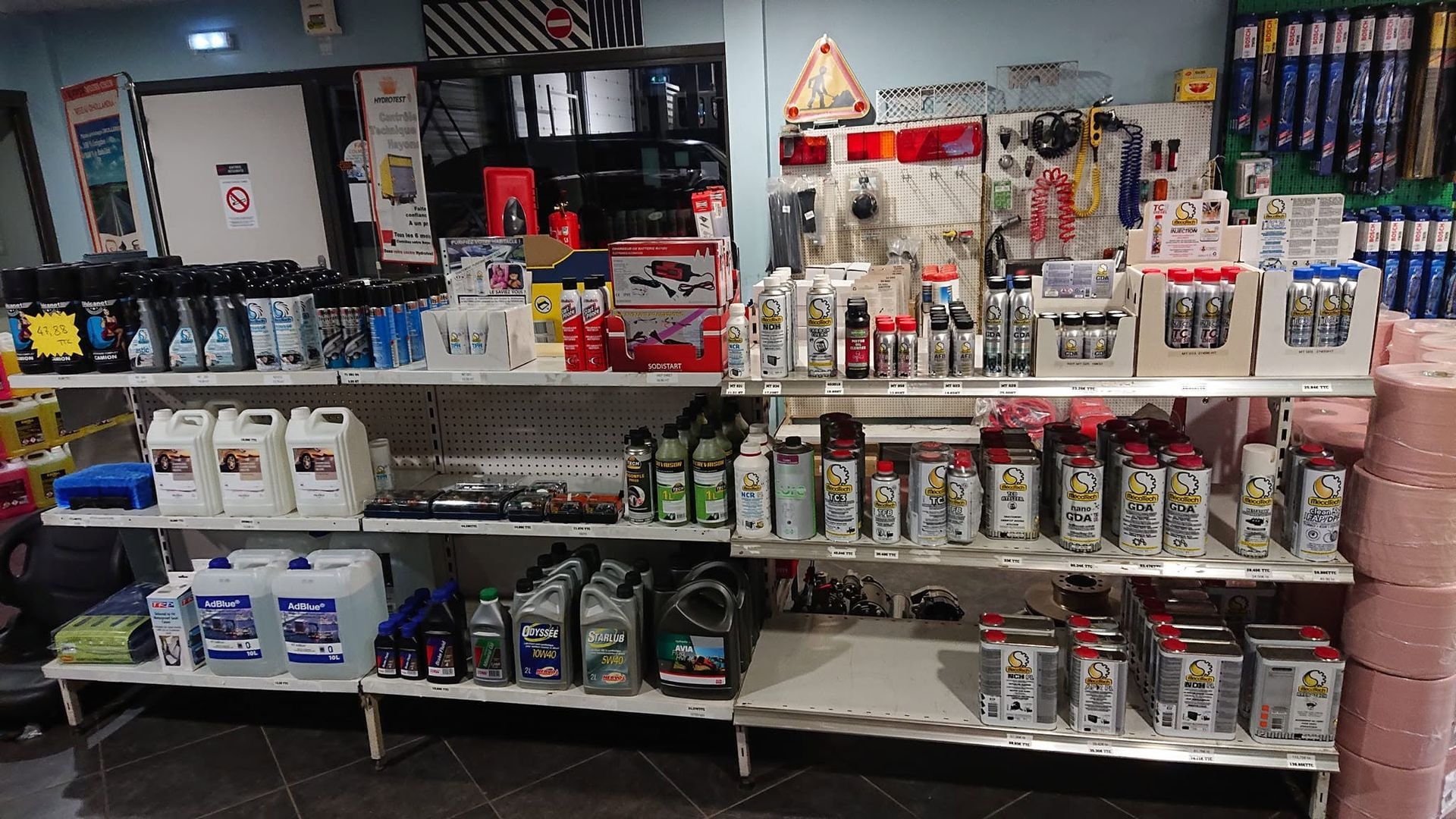L'intérieur d'un magasin de pièces auto, étagères remplies de produits d'entretien.