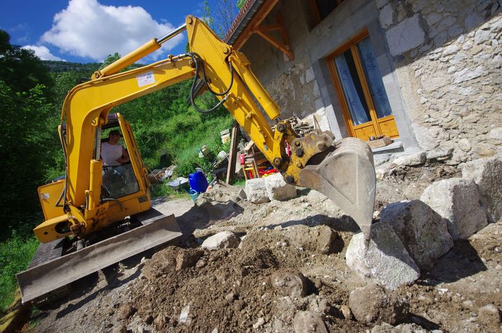 Une pelleteuse dans la cour d'une maison
