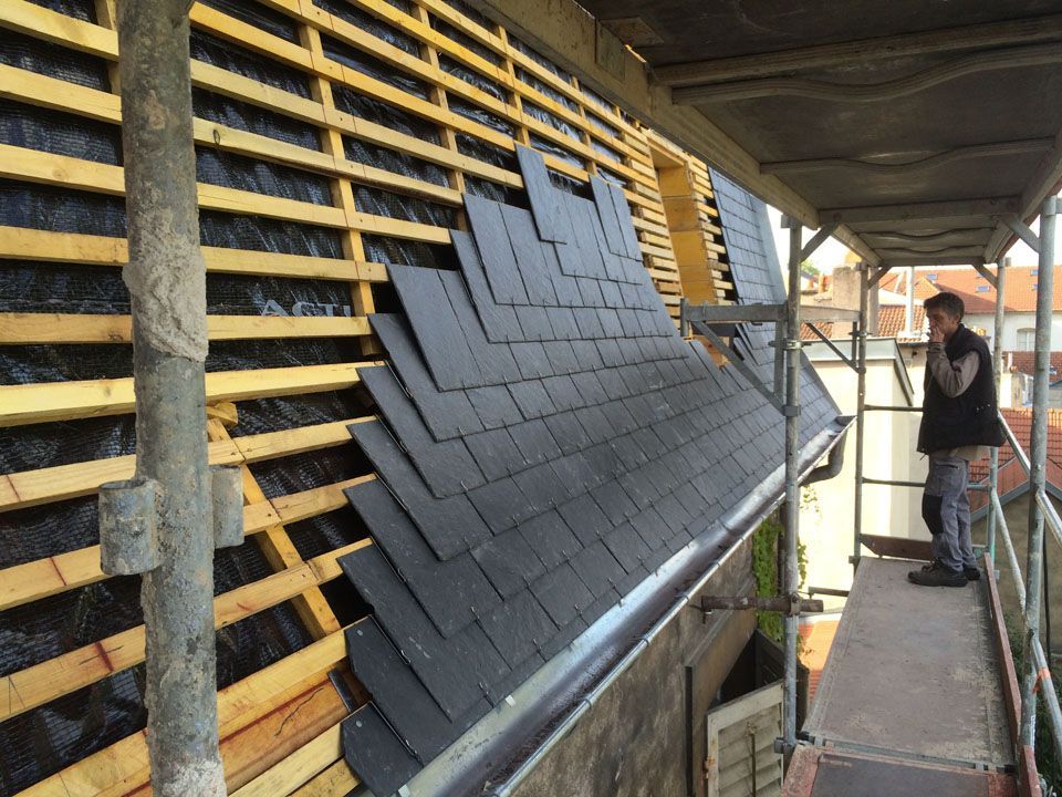 Pose d'ardoise sur une toiture en ville