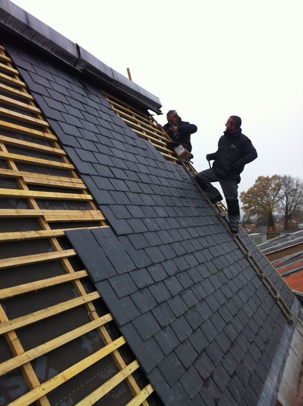 Deux ouvriers qui discutent pendant la pose de la toiture