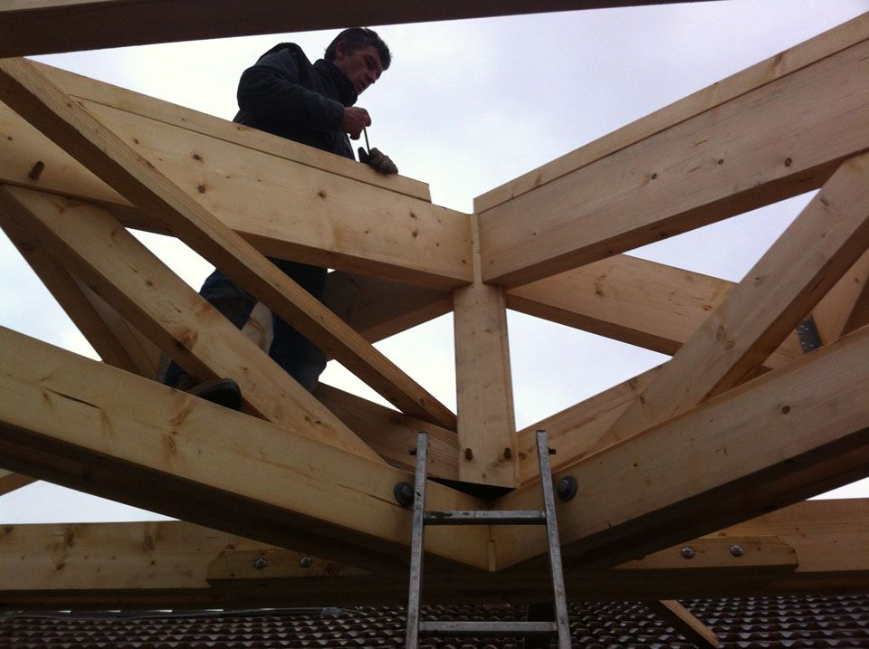 Gros plan sur un ouvrier qui travaille sur le chapeau d'une charpente