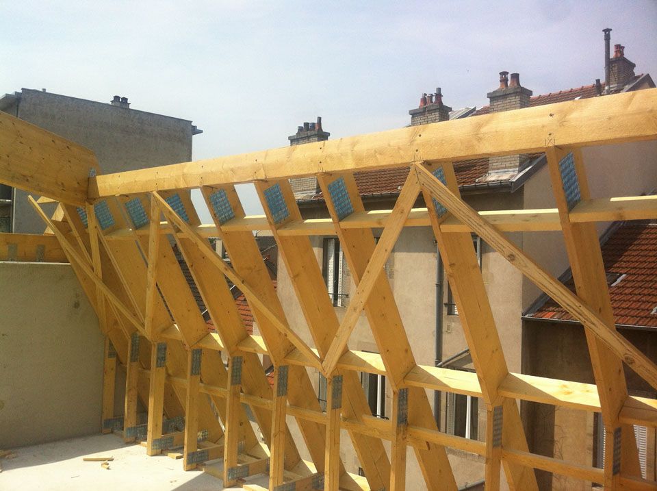 Gros plan sur une charpente en bois avec une forme complexe