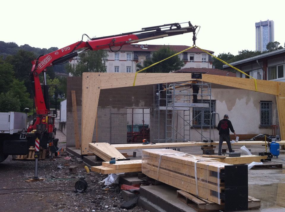 Installation d'une charpente en lamelles collées avec une grue