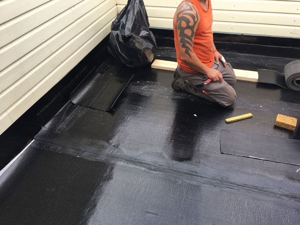 Ouvrier en train de poser une membrane d'étanchéité