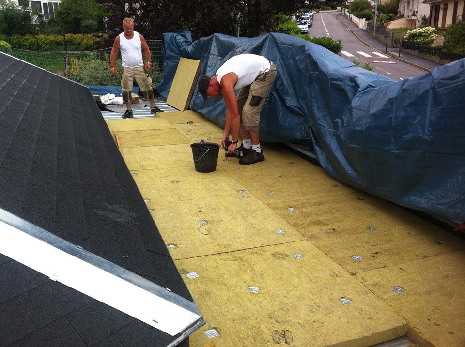 Deux ouvriers qui posent de l'étanchéité par-dessus l'isolant